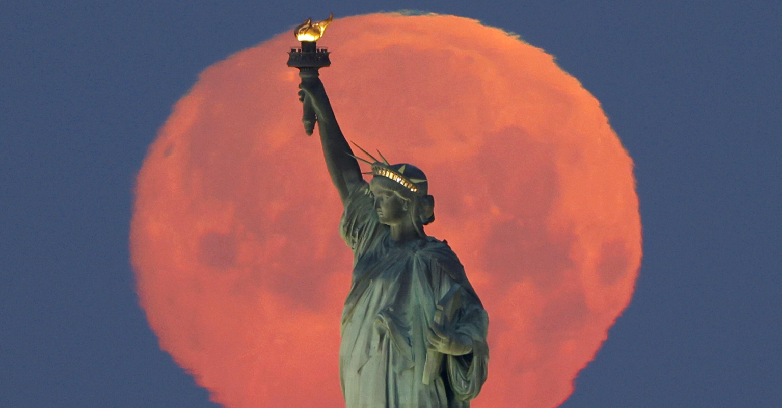 Pink Supermoon creates stunning halo around Statue of Liberty
