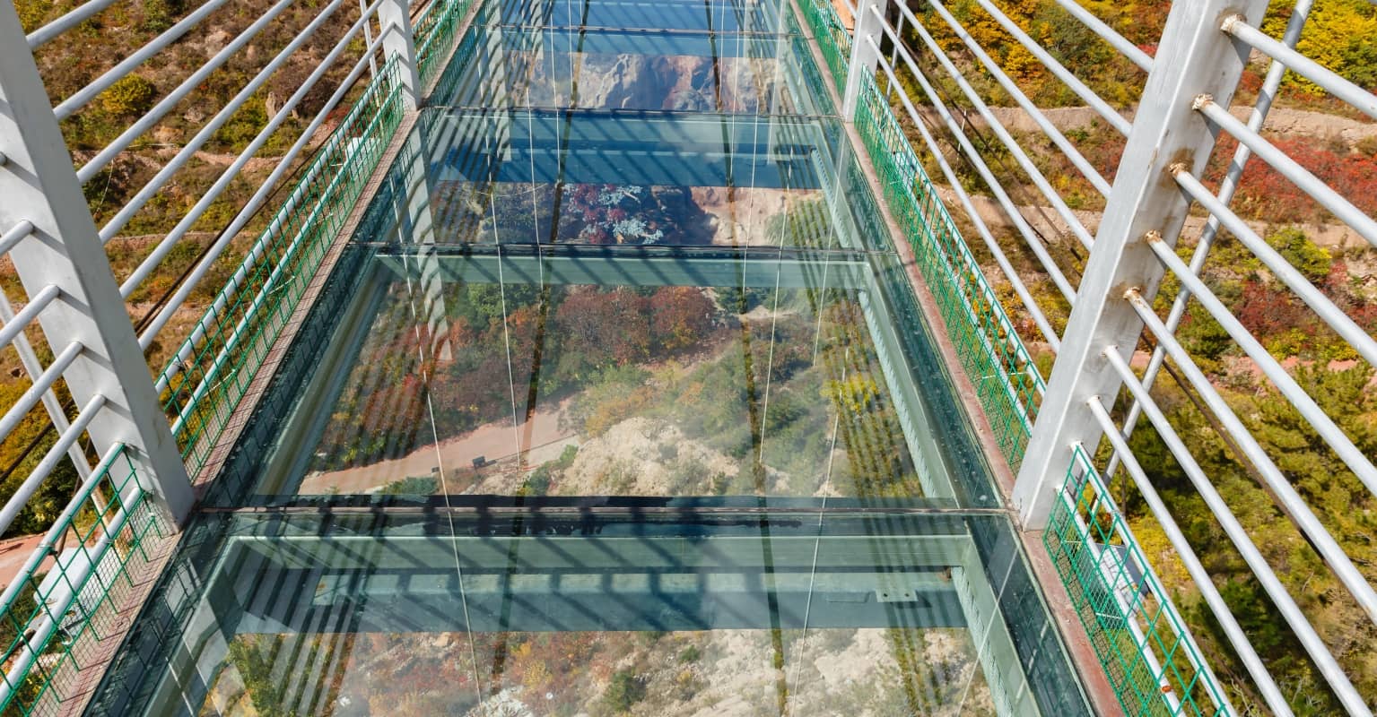 Tourist dangles 330ft in the air as glass bridge in China is damaged by strong winds