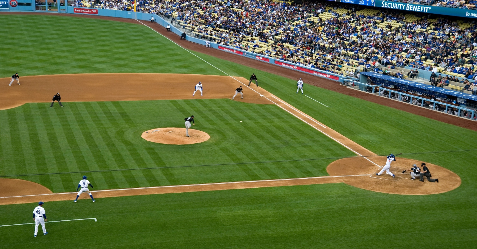 Mom makes one-handed catch while holding baby at baseball game