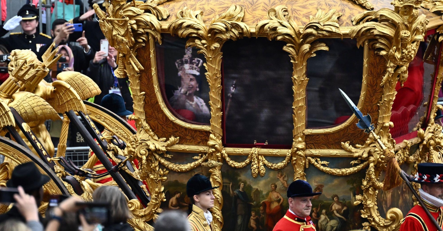 Hologram of the Queen waves to crowd from historic Gold State Coach